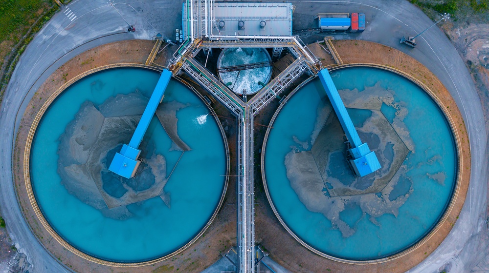 Aerial view of a water treatment plant with two circular clarifier tanks