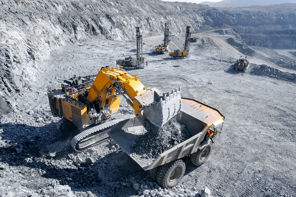 Aerial view of an excavator loading a haul truck in an open-pit mine